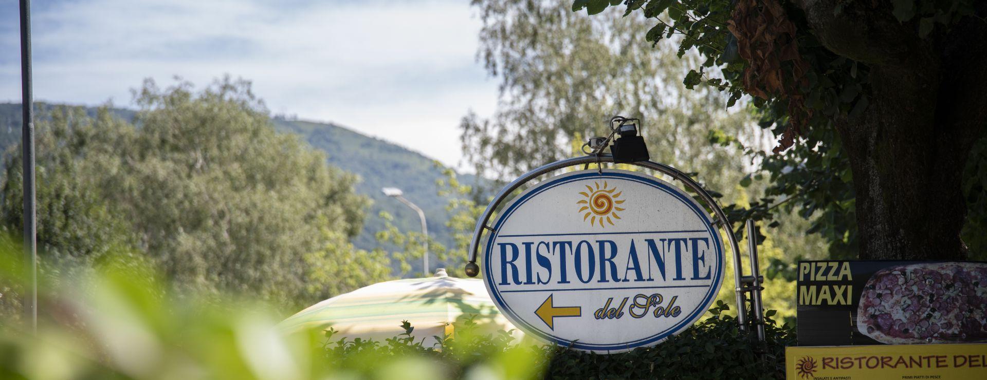 Insegna del Ristorante del Sole con offerta Pizza Maxi in un ambiente naturale.