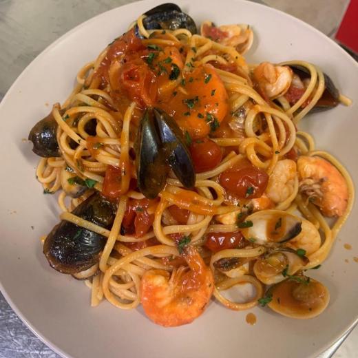 Spaghetti ai frutti di mare con pomodorini e prezzemolo.